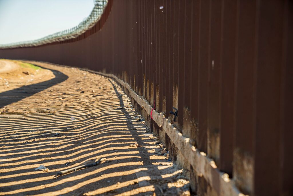 Long steel border barrier in a sunny desert