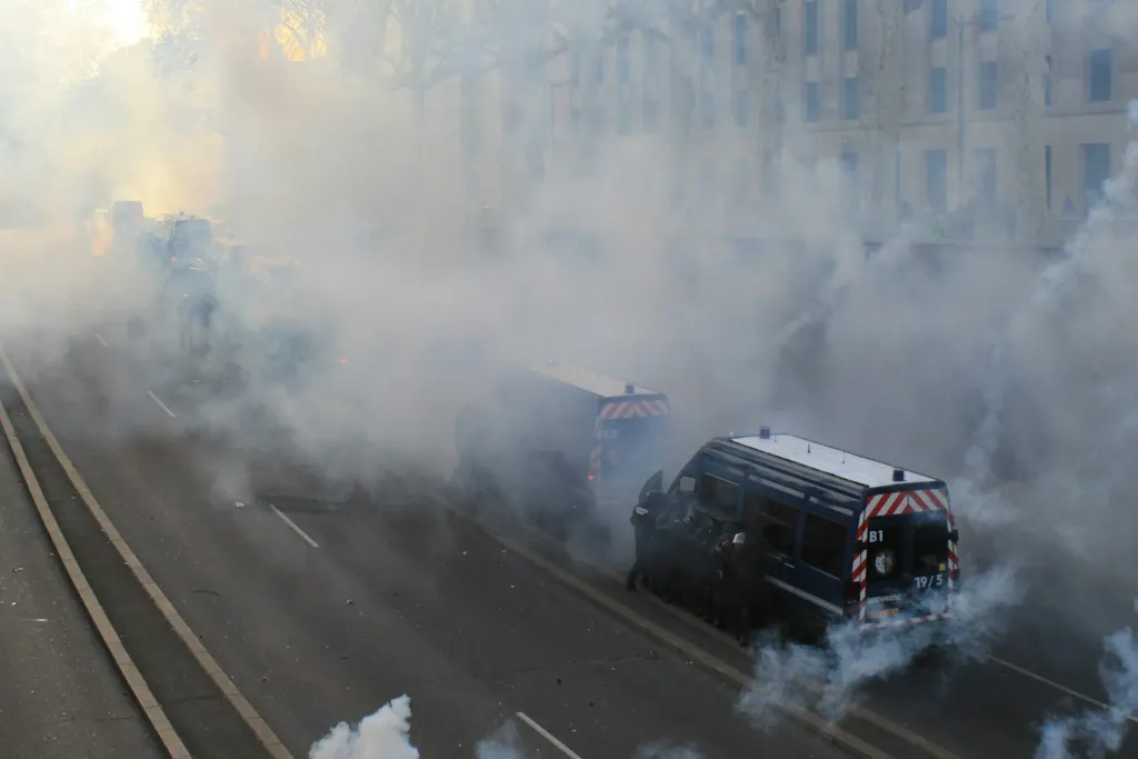 City street filled with drifting smoke beside an apartment building
