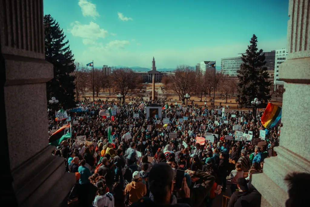 Crowd of people protesting in front of a large building