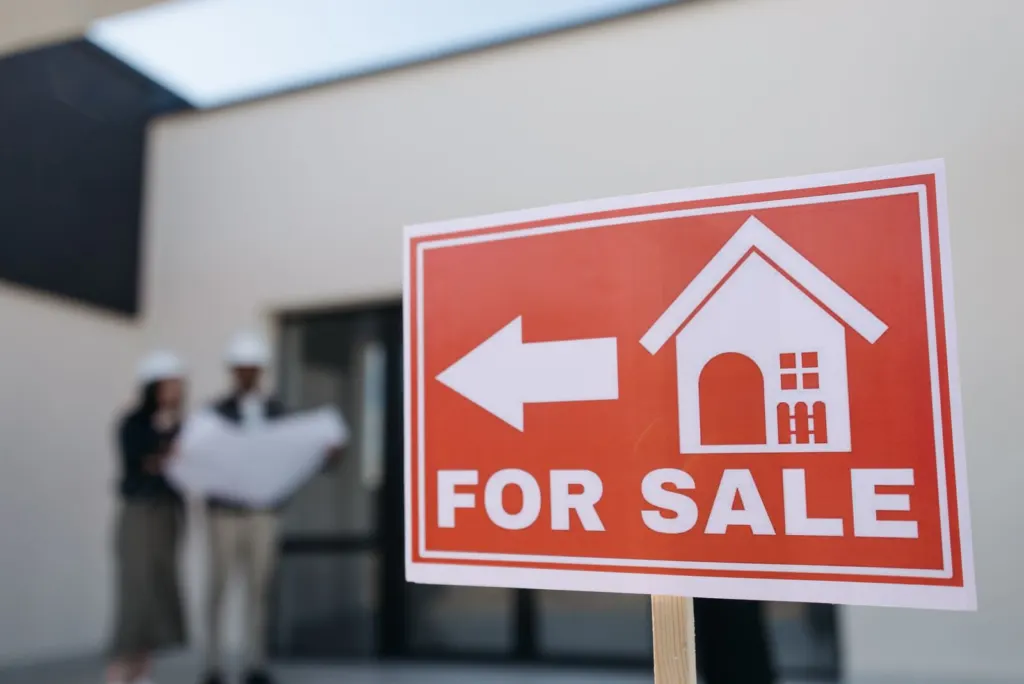 Hours of work: Red for sale sign standing in front of a property