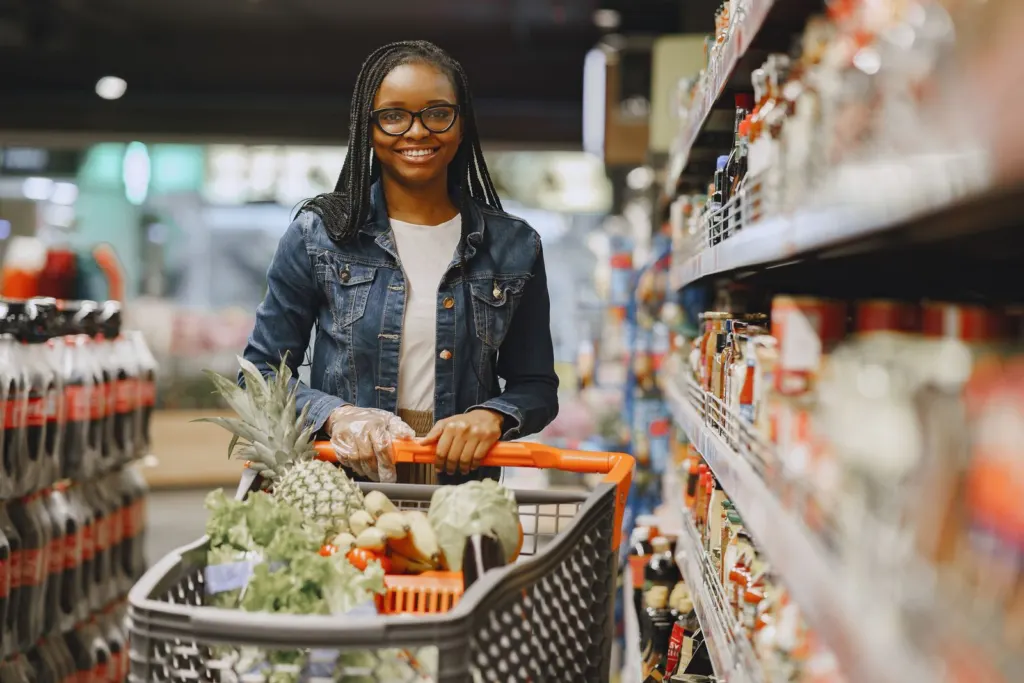 Hours of work: Woman pushing a shopping cart down a grocery store aisle