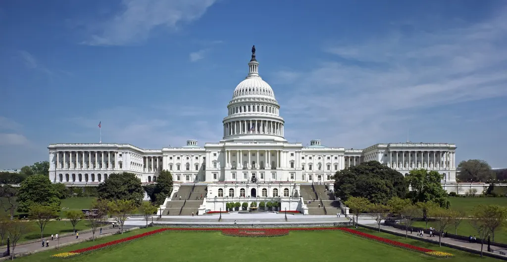 White dome and west front of the United States Capitol under a blue sky