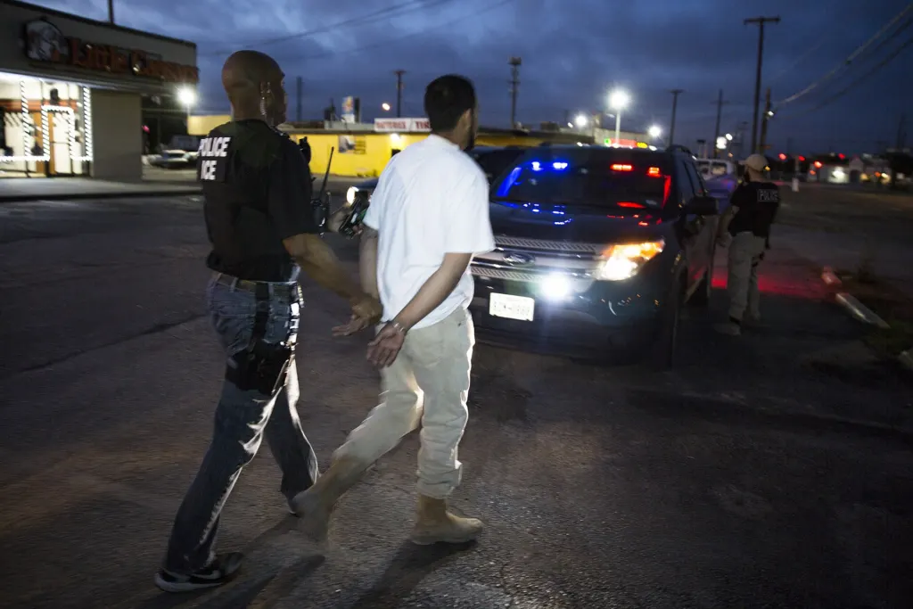 Immigration officers in tactical vests during an arrest operation in Dallas