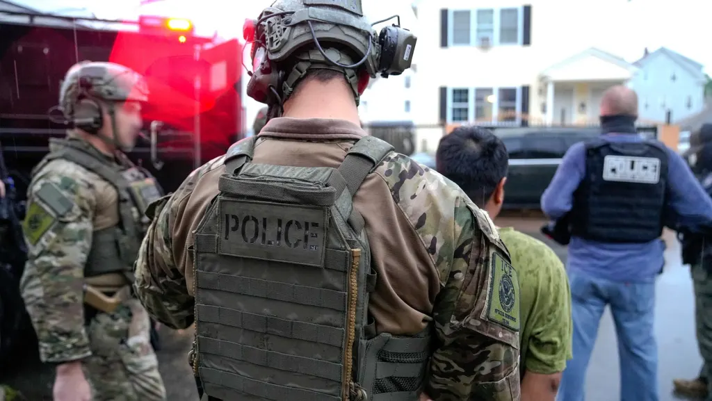 Federal officers detaining a man during an operation in Warwick