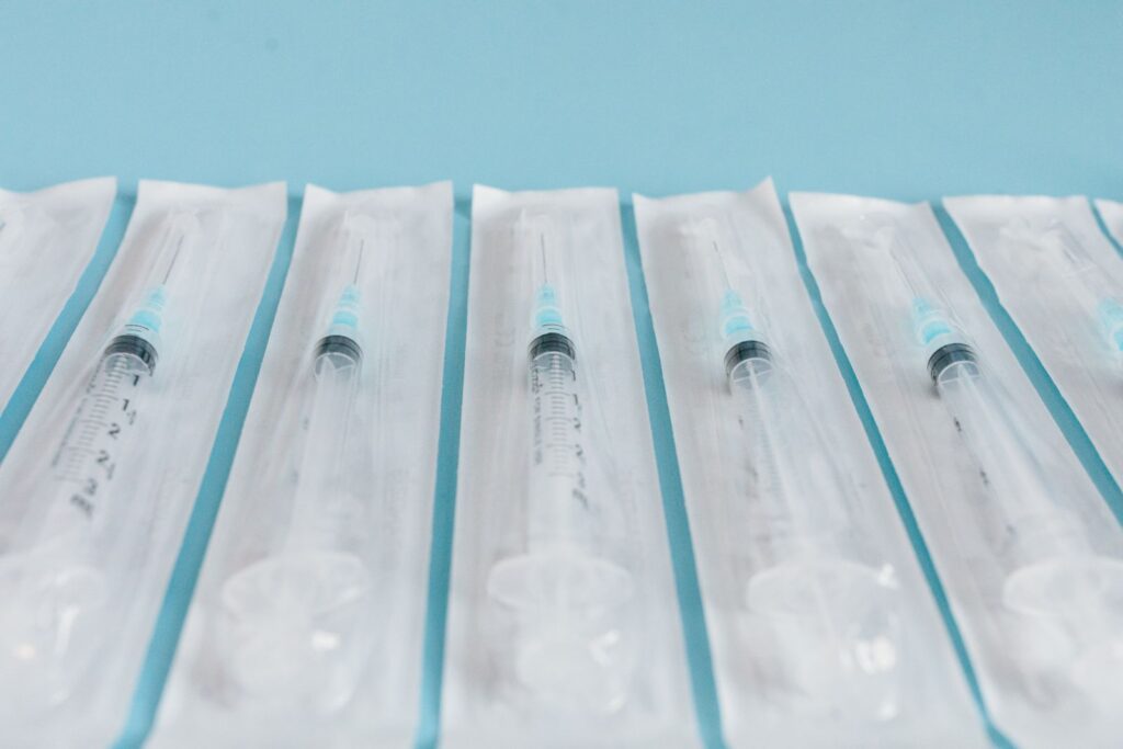 Sterile syringes in packaging on a blue background