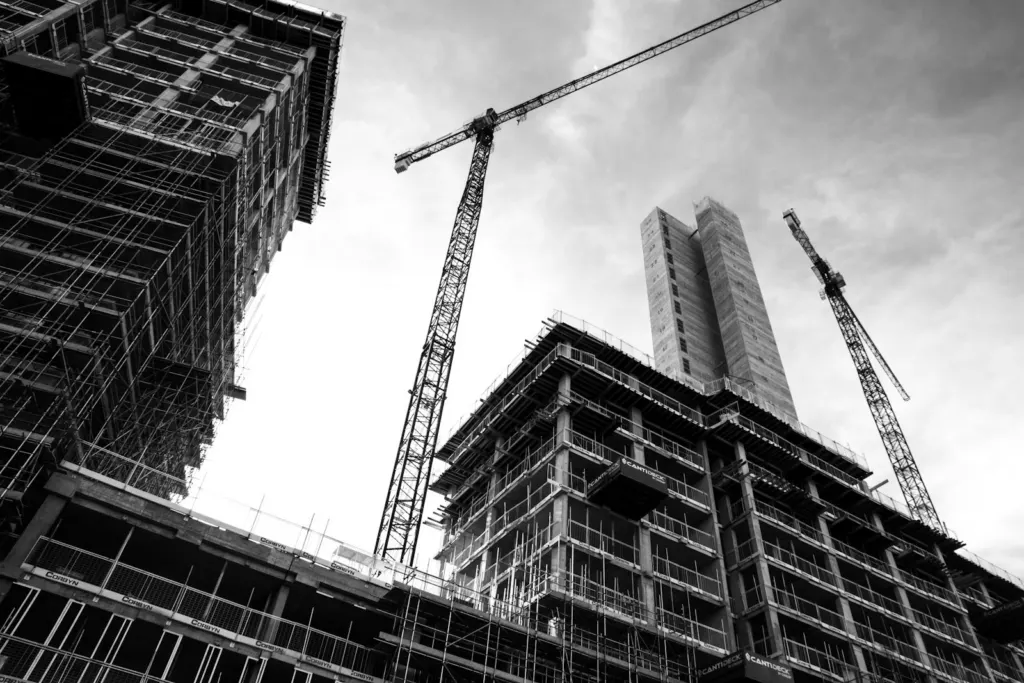 Black and white view of a construction crane next to a building