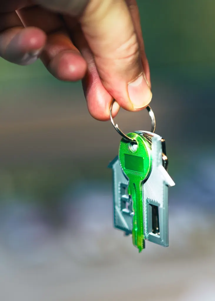 Miley Cyrus donation: A hand holding a small house shaped keychain in warm sunlight