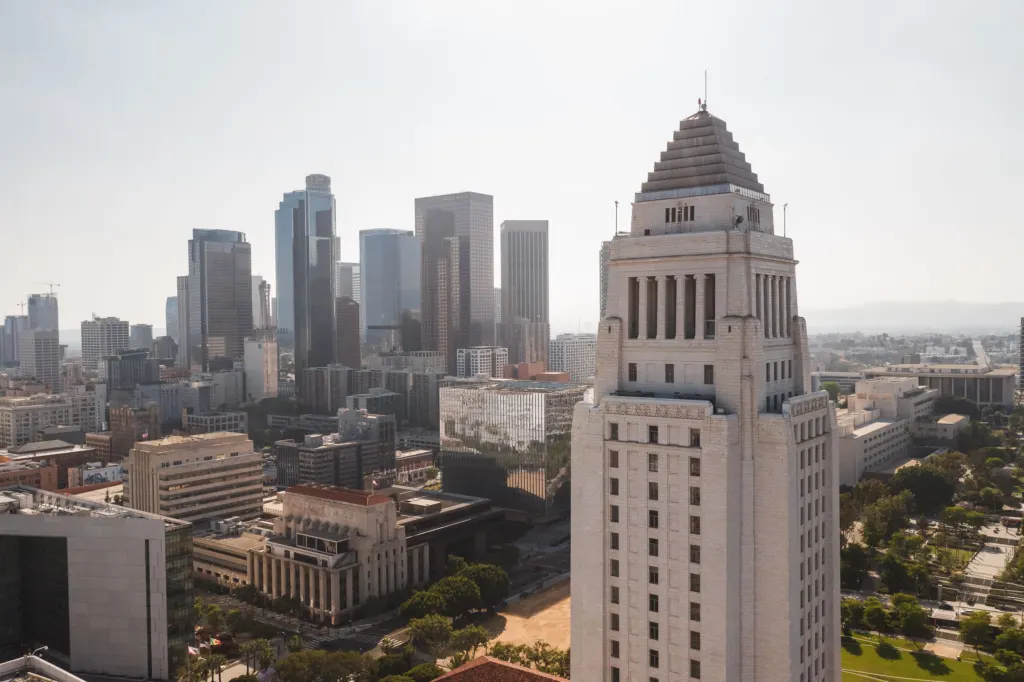 Aerial view of Los Angeles City Hall with the downtown skyline behind it