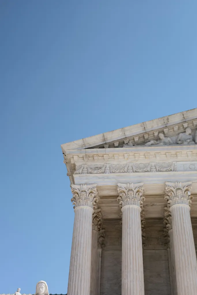 Tall white building with columns and a clock in Washington